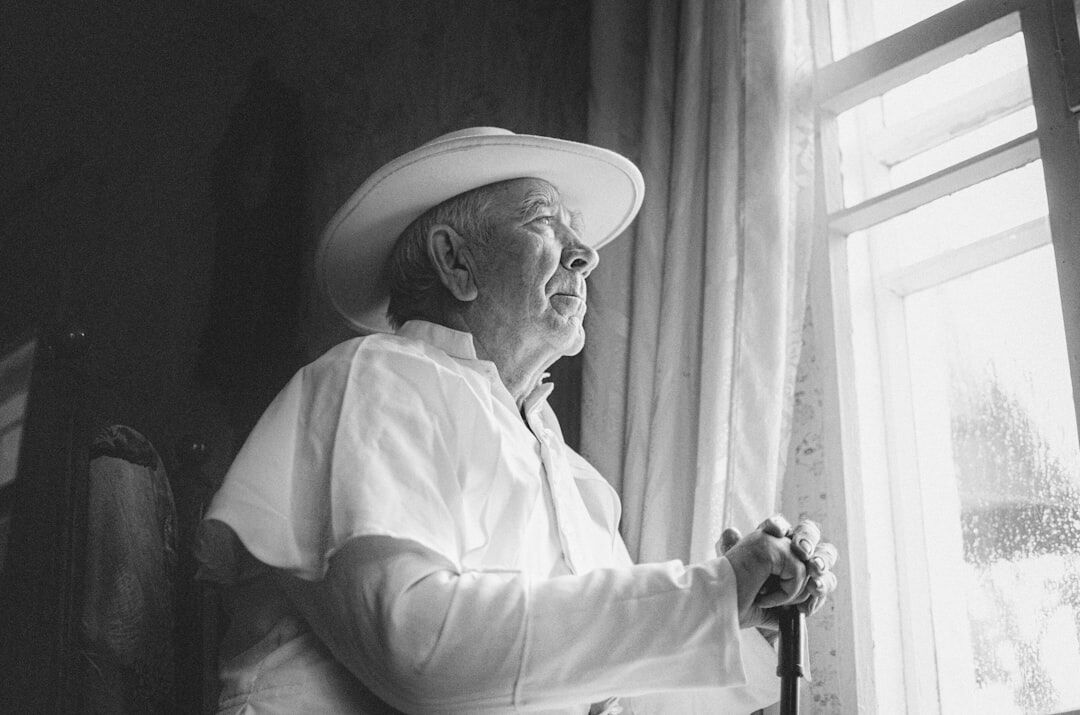 elderly couple by window with curtains